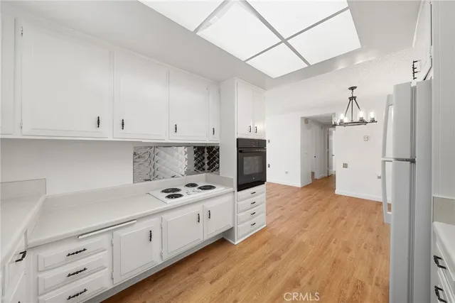 a kitchen with granite countertop a stove sink and cabinets