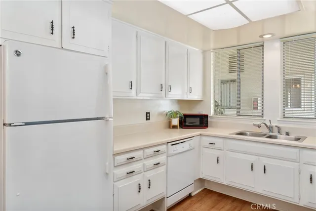 a kitchen with granite countertop white cabinets and appliances