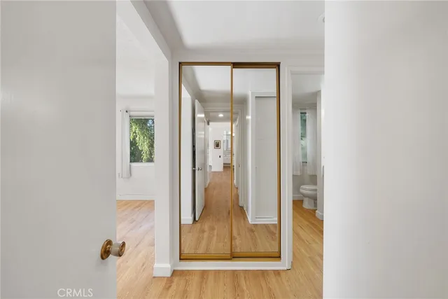 a view of empty room with wooden floor and fan