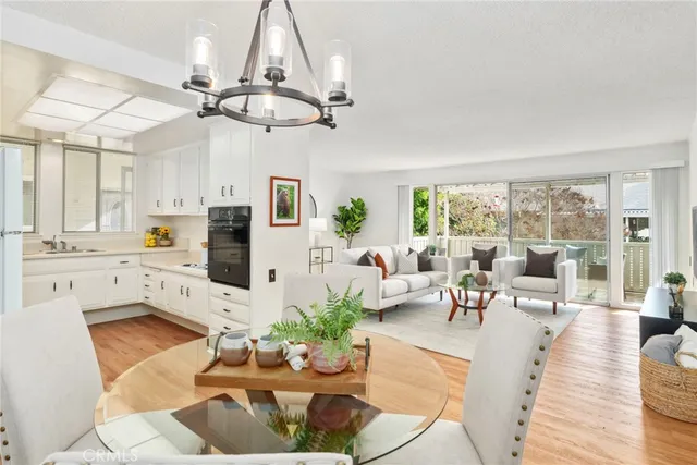 a dining room with furniture a chandelier and wooden floor