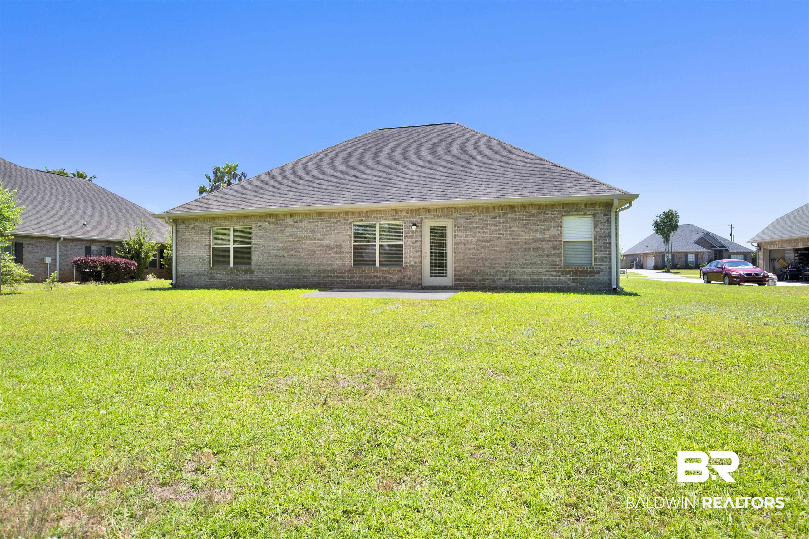 10910 Roanoke Loop Daphne, AL 36526 - Photo 31 of 33 Back of house featuring a lawn, a patio area, and brick siding