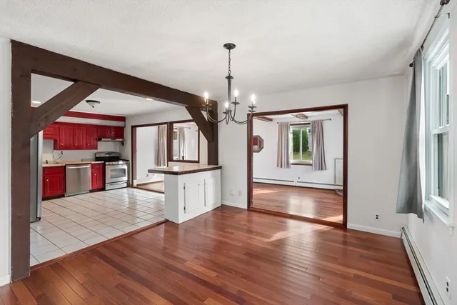 a kitchen view with wooden floor and electronic appliances