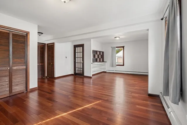 a bedroom with a large bed and wooden floor