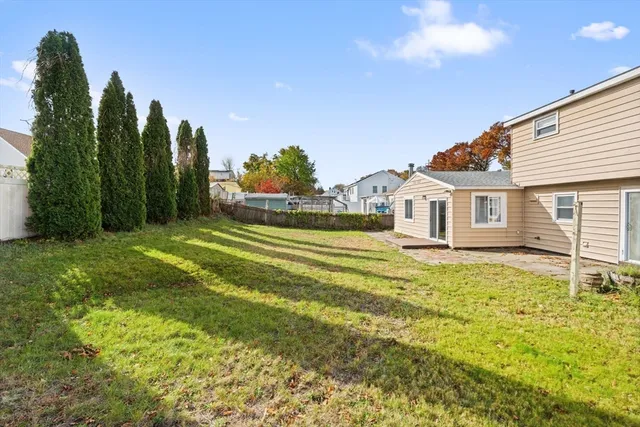 a view of a big house with a big yard and large trees