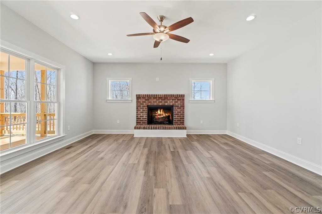 2148 Sandy Hook Road Goochland, VA 23063 - Photo 6 of 34 an empty room with wooden floor chandelier fan and windows