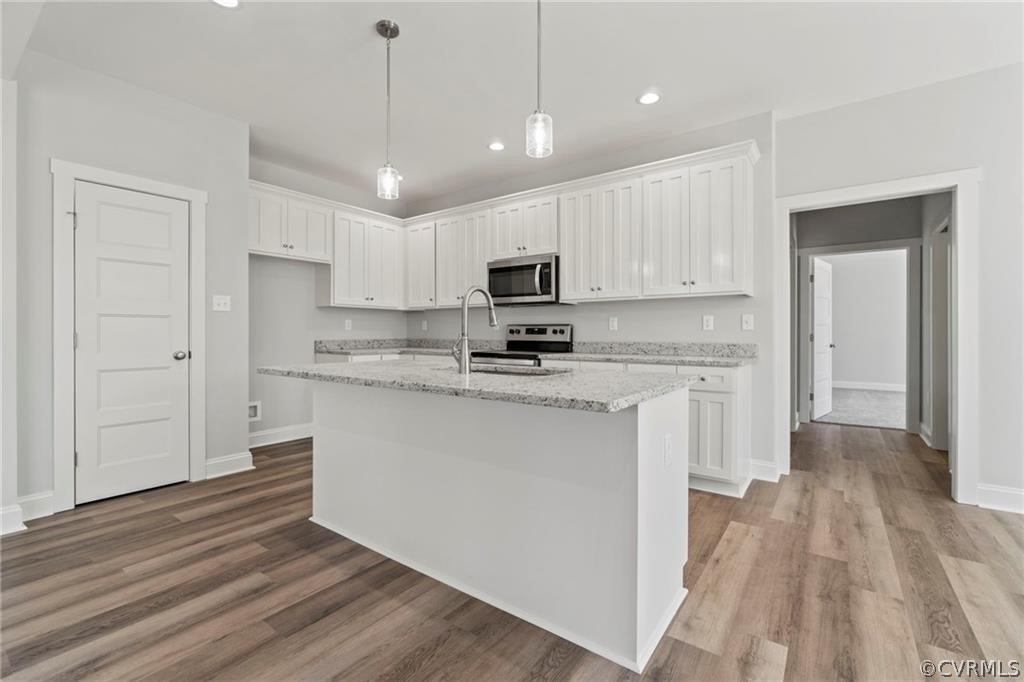 2148 Sandy Hook Road Goochland, VA 23063 - Photo 10 of 34 a kitchen with granite countertop a refrigerator a sink dishwasher a stove and white cabinets with wooden floor