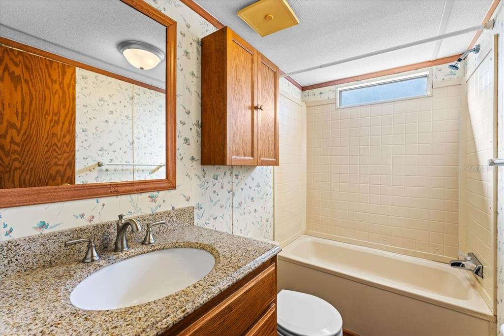 12001 Rhodine Road Riverview, FL 33579 - Photo 31 of 61 a bathroom with a granite countertop tub sink and mirror
