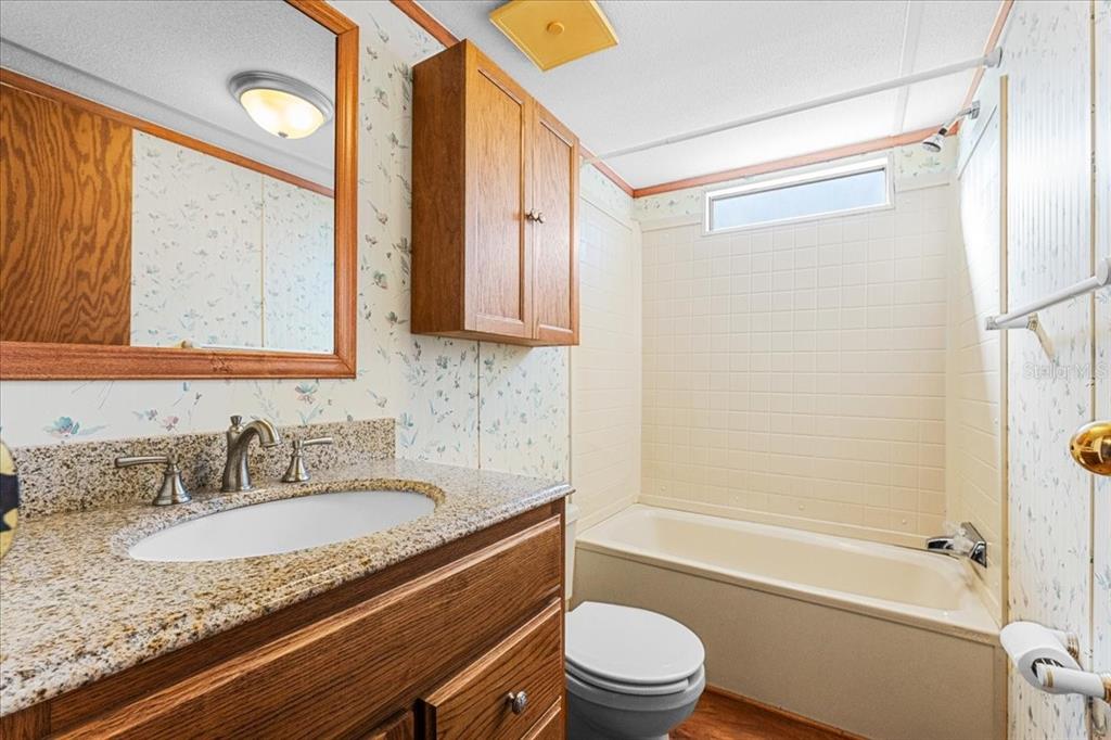 12001 Rhodine Road Riverview, FL 33579 - Photo 33 of 61 a bathroom with a granite countertop sink toilet and shower