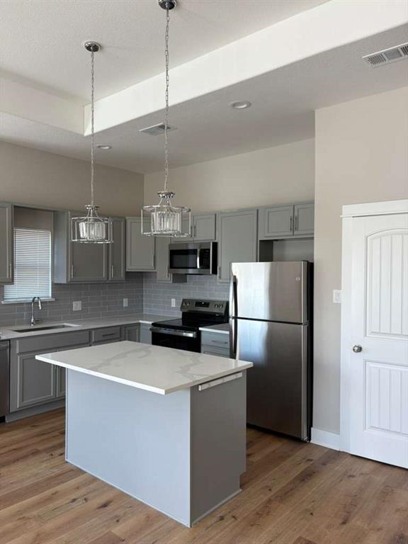 911 Nata Lane Dallas, TX 75253 - Photo 2 of 7 a kitchen with a refrigerator a sink and dishwasher with wooden floor