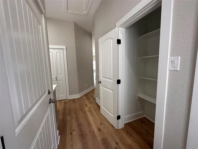 a view of a hallway with wooden floor and entryway