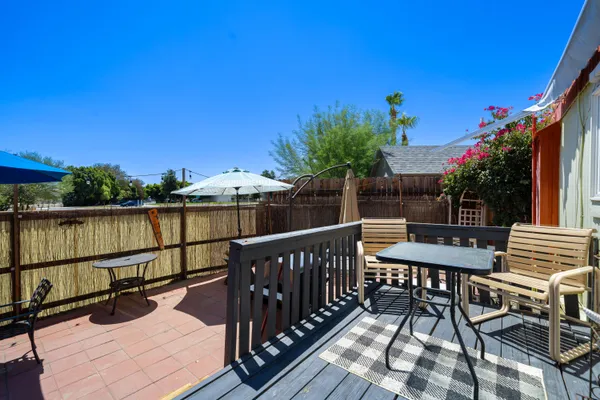 a patio with a table and chairs under an umbrella