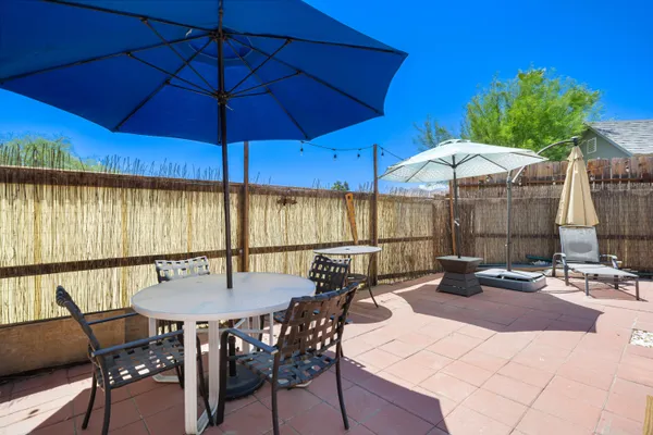 a view of a patio with a table and chairs under an umbrella