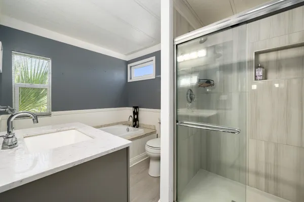 a spacious bedroom with a bed and a chandelier