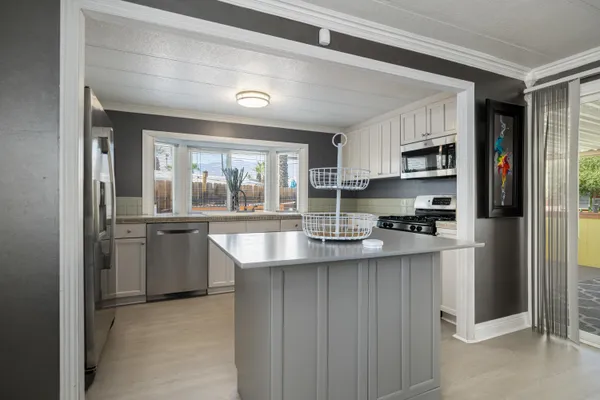 a kitchen with granite countertop white cabinets and stainless steel appliances