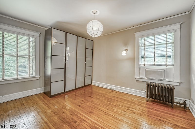 42 Gates Avenue Montclair, NJ 07042 - Photo 23 of 44 an empty room with wooden floor fan and windows