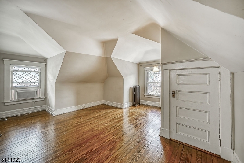 42 Gates Avenue Montclair, NJ 07042 - Photo 34 of 44 an empty room with wooden floor cabinet and windows