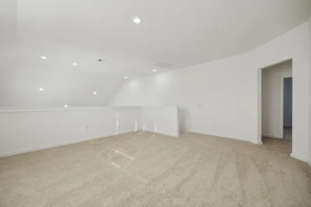 an empty room with white wall and hallway