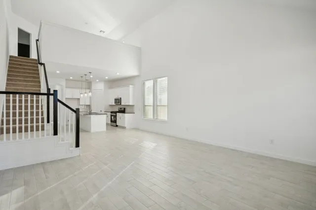 a view of empty room with wooden floor and windows