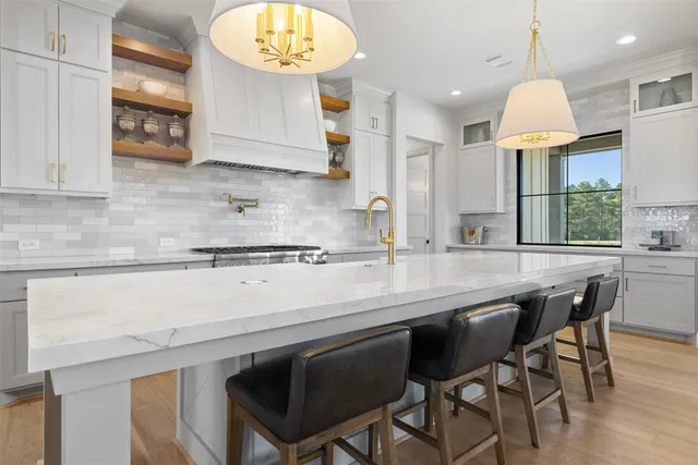 a kitchen with stainless steel appliances granite countertop a sink a stove and a microwave