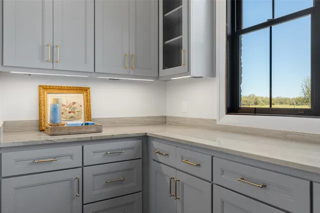 a kitchen with granite countertop white cabinets and a window