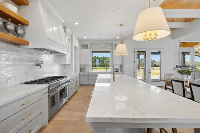 an open kitchen with kitchen island granite countertop stove and cabinets