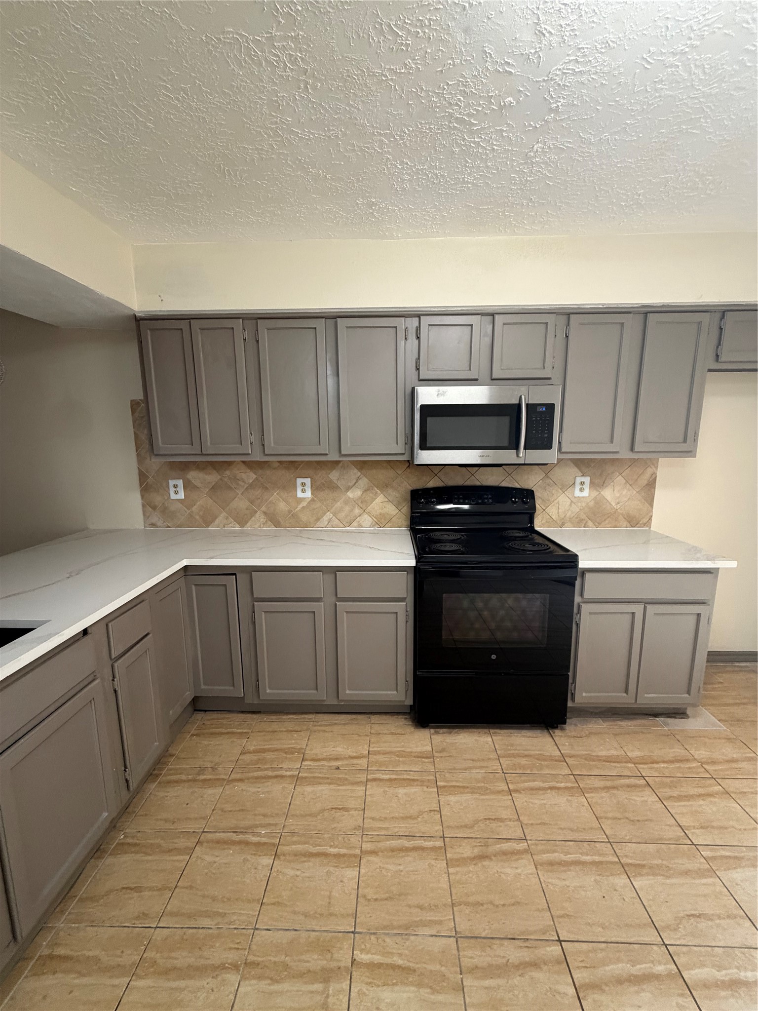 9327 Westacre Place Houston, TX 77083 - Photo 2 of 7 a kitchen with a stove top oven and cabinets