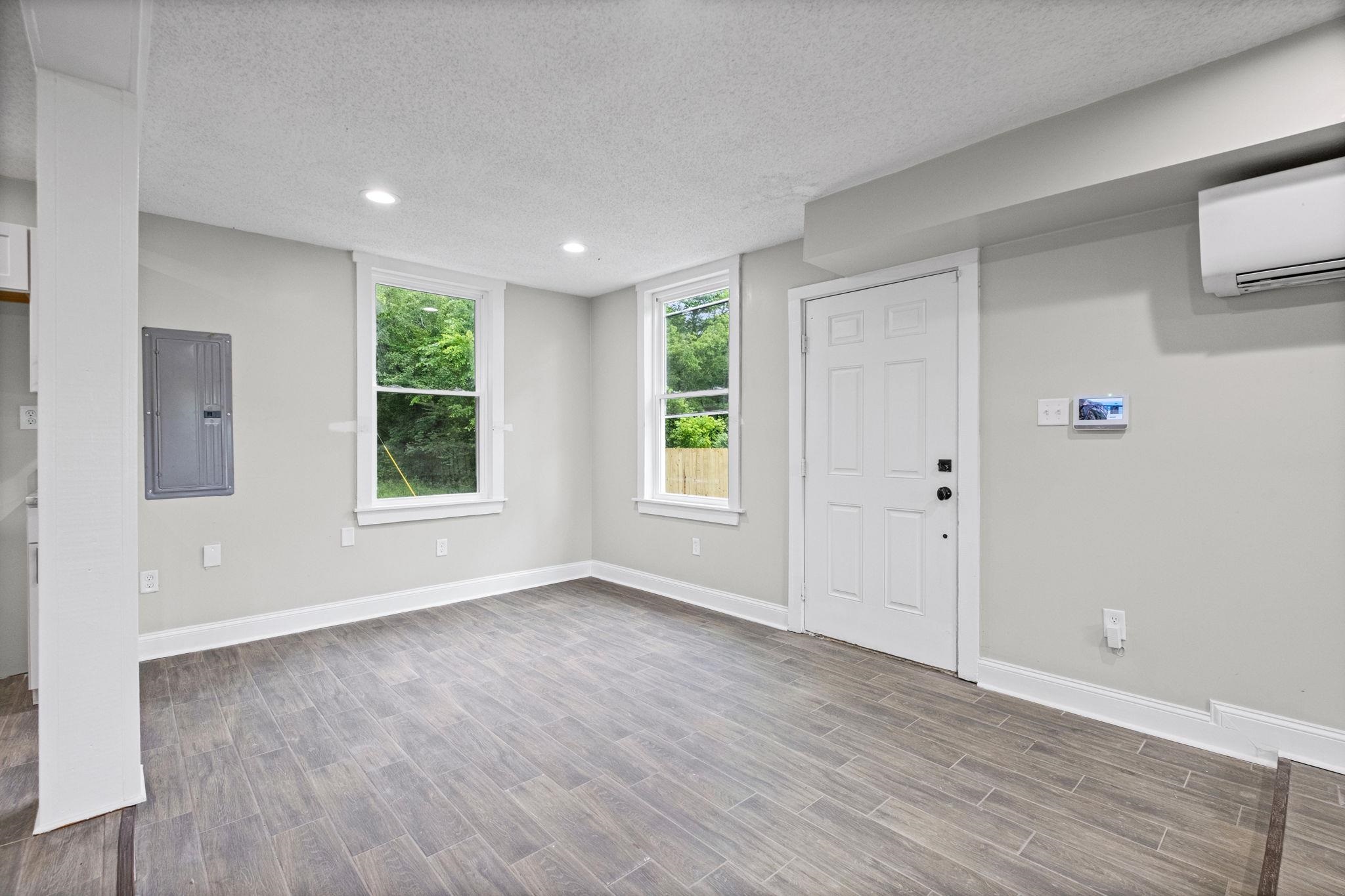 5843 Stewart Road Lakeland, TN 38002 - Photo 10 of 26 Spacious room featuring wood-look flooring, multiple windows, recessed lighting, and a white paneled door