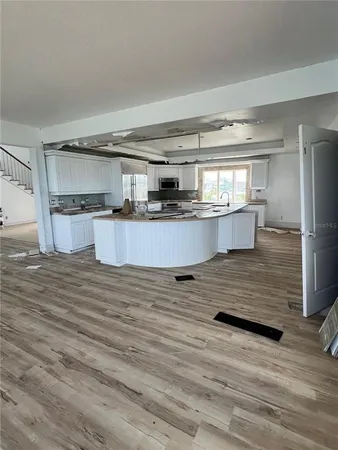 a kitchen with kitchen island granite countertop a sink and wooden cabinets