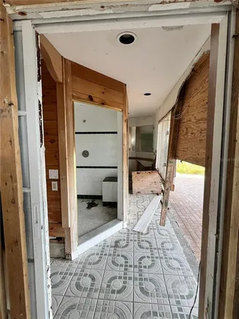 a view of a hallway to a livingroom with furniture and front door
