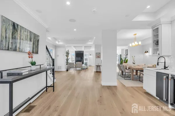 a view of a dining room with furniture a chandelier and wooden floor
