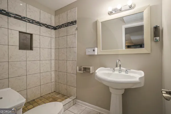 a bathroom with a sink toilet and shower