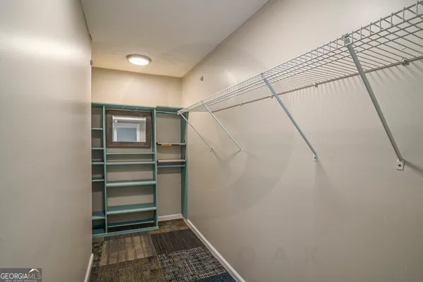 a view of walk in closet with empty racks