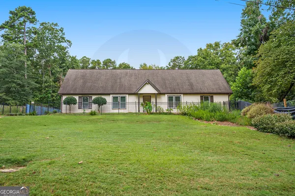 a view of a big house with a big yard and large trees