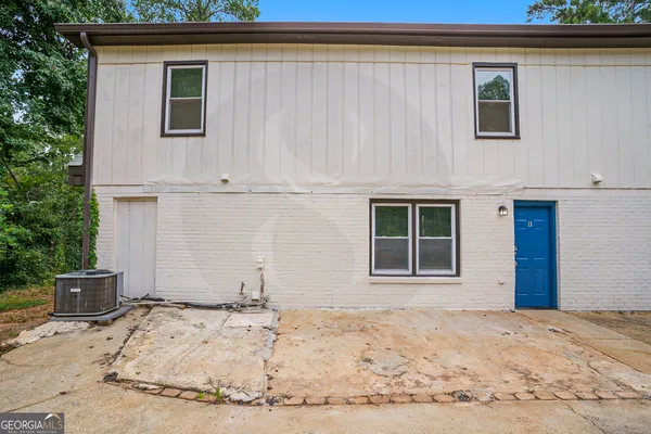 a white house that has a tree in front of it