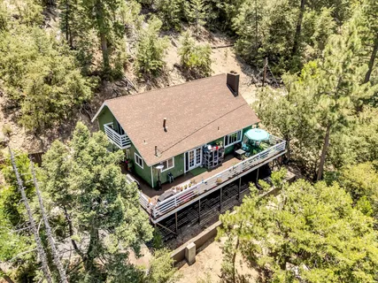 a view of house with backyard and trees in the background
