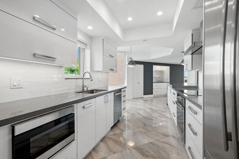 300 Southeast 5th Avenue, Unit 5180 Boca Raton, FL 33432 - Photo 17 of 45 a large kitchen with stainless steel appliances a large counter top a stove and a refrigerator
