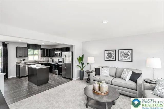 a living room with a couch and a dining table with kitchen view