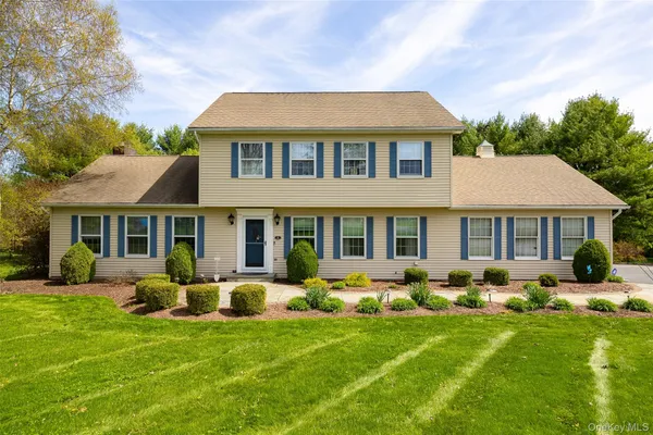 a front view of a house with a yard and potted plants