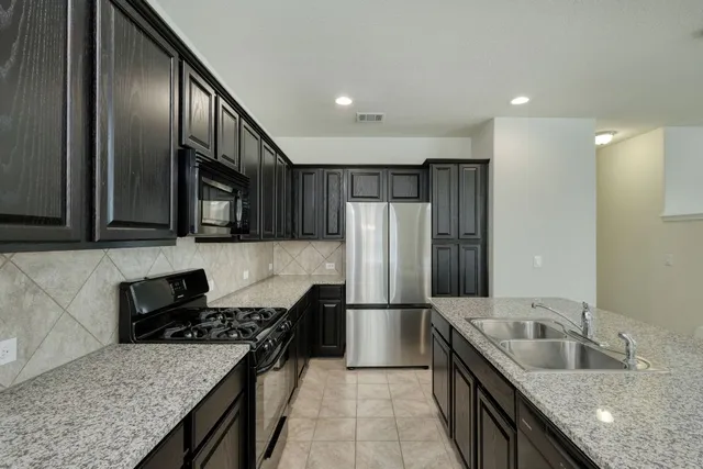 a kitchen with granite countertop stainless steel appliances and wooden cabinets