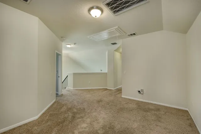 an empty room with a ceiling fan and windows
