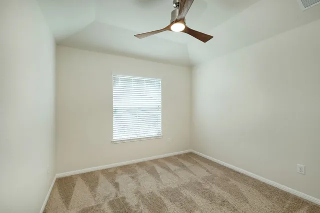 an empty room with a window and a fan