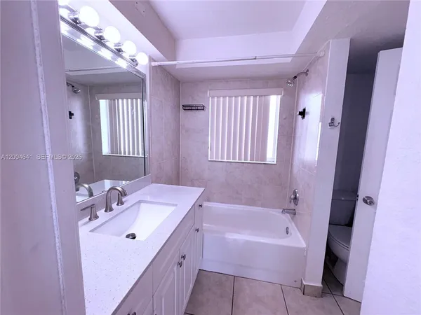 a bathroom with a tub sink and mirror