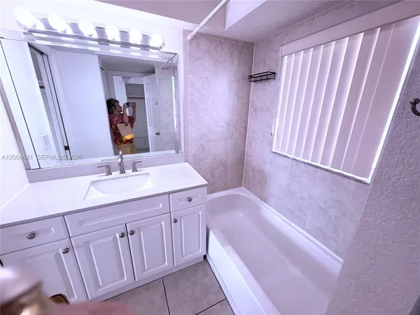 a bathroom with a sink a tub and a mirror