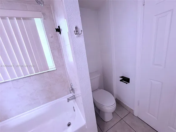 a bathroom with a granite countertop shower and a toilet