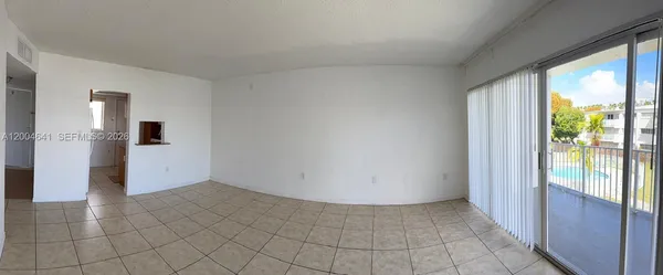 a view of a hallway with wooden floor and a kitchen