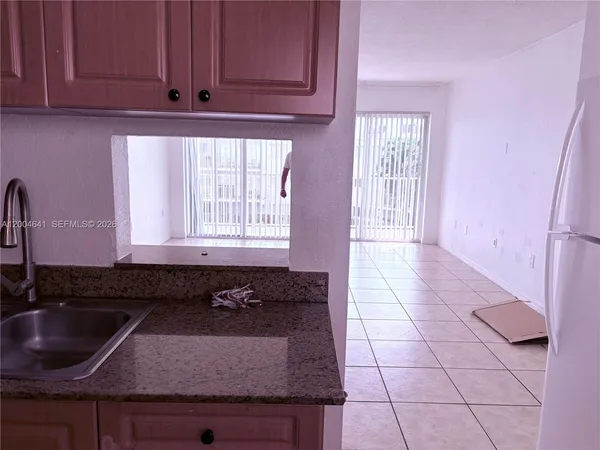 a kitchen with granite countertop a sink a stove and cabinets