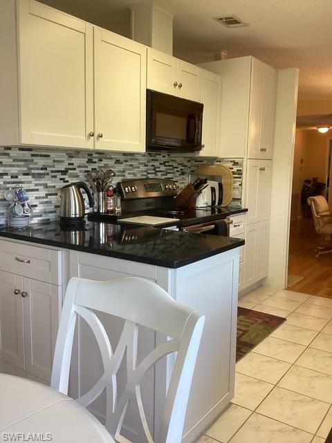225 Belle Isle Circle Naples, FL 34112 - Photo 12 of 48 a kitchen with a sink a stove and a microwave