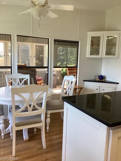 225 Belle Isle Circle Naples, FL 34112 - Photo 13 of 48 a kitchen with a table chairs stove and wooden floor