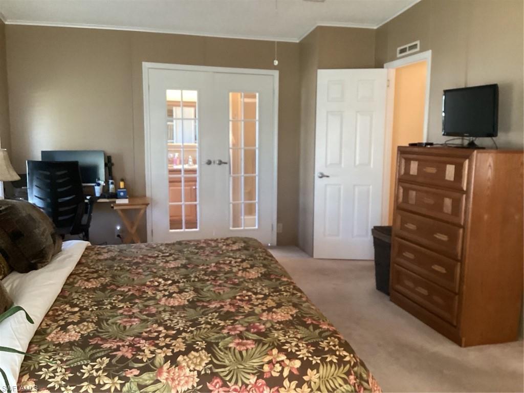 225 Belle Isle Circle Naples, FL 34112 - Photo 16 of 48 a bedroom with a bed and flat screen tv