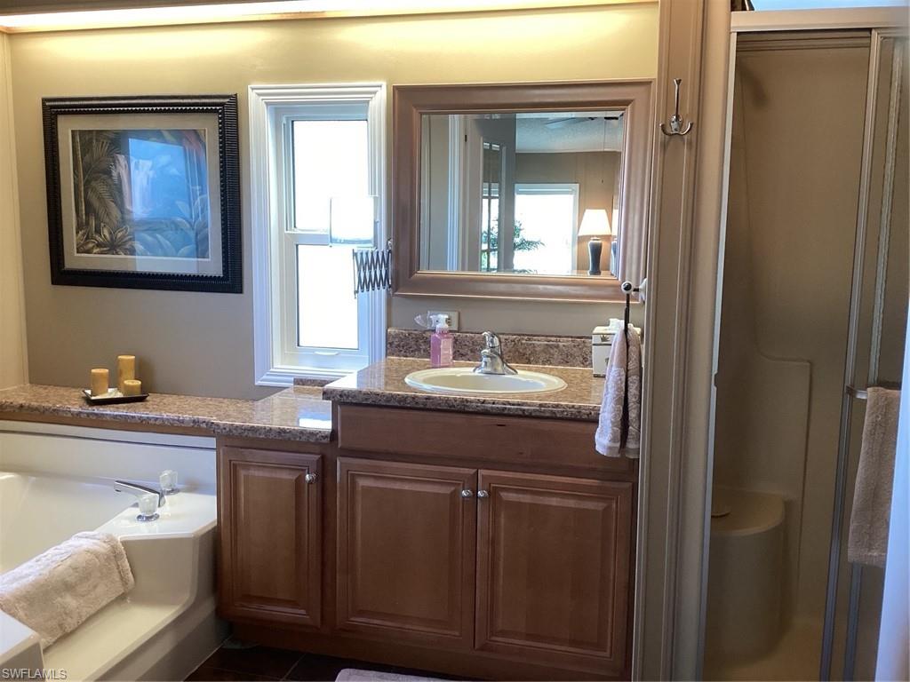 225 Belle Isle Circle Naples, FL 34112 - Photo 17 of 48 a bathroom with a sink and a mirror